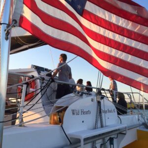 People aboard Sail Wild Hearts with American Flag